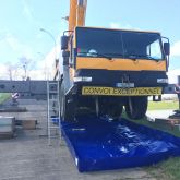 Installation d'une rétention souple sous camion durant une opération de maintenance mécanique